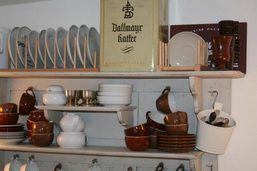 a shelf filled with dishes and utensils at Gästehäuser Hölle 12 und Hölle 13 in Bamberg