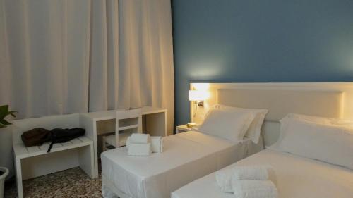 a bedroom with two white beds and a blue wall at Regina Margherita - Bed and Breakfast & Rooftop Lounge Bar in Siracusa