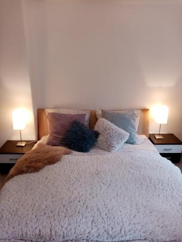 a bedroom with a bed with pillows and two lamps at Vila Anton in Karlovy Vary