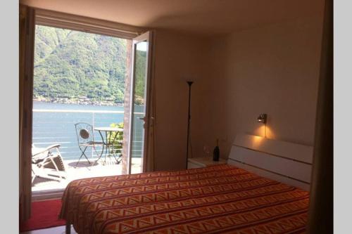 a bedroom with a bed and a view of the water at Bride apartment Colonno in Colonno