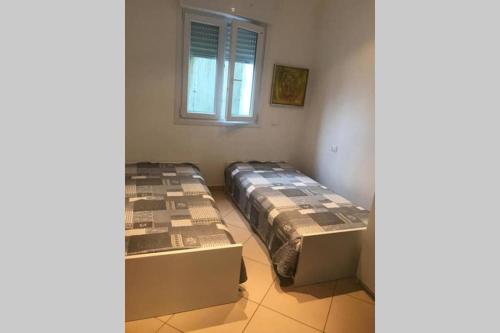 two beds sitting in a room with a window at Bride apartment Colonno in Colonno