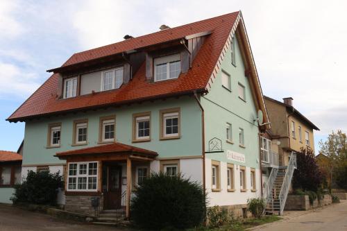 a house with a red roof on a street at D´r Rechenmacher in Michelfeld