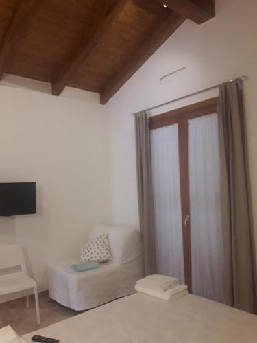 a room with a bed and a couch and a television at Magnolia Rooms in Civitavecchia