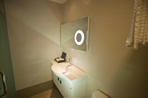 y baño con lavabo blanco y espejo. en Euro+ Hotel Johor Bahru, en Johor Bahru