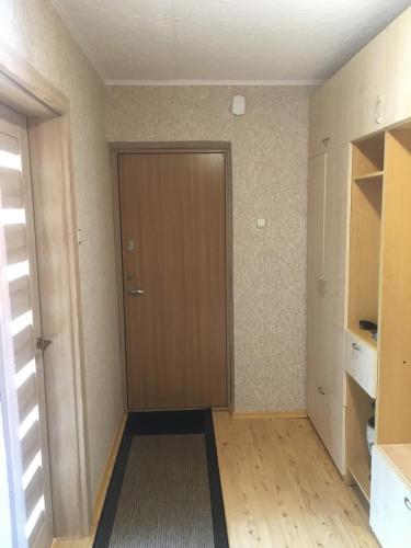 a hallway with a brown door in a room at Butas Vladas in Nida
