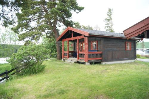 une petite cabine dans une cour avec une pelouse dans l'établissement Odin Camping AS, à Svensrud