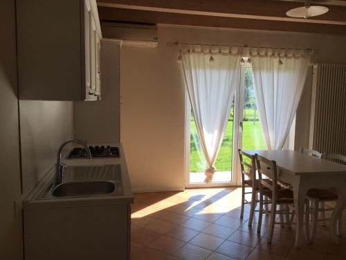 a kitchen with a sink and a table and a window at Agriturismo Maso Bergot in Arco