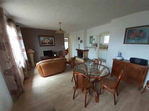 un salon avec une table en verre et des chaises dans l'établissement Le Beau Val, à Saint-Aignan