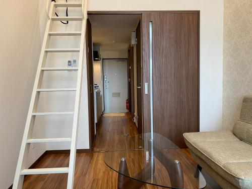 a room with a glass table and a ladder at ホテルトーマス牧港ヴィラ in Urasoe