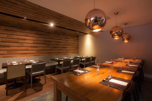 a dining room with tables and chairs and lights at Hotel WZ Jardins in Sao Paulo