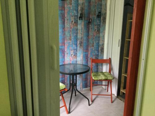 a table and two chairs in a room at Balatongyöngye vendégház in Küngös