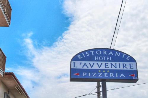 a sign for a hotel in front of a cloudy sky at Hotel Ristorante L'Avvenire in Gizzeria