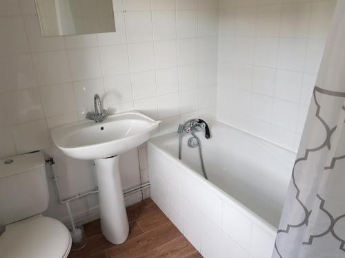 a bathroom with a sink and a toilet and a tub at Bar du Marché - Hôtel - Restaurant in Langeais