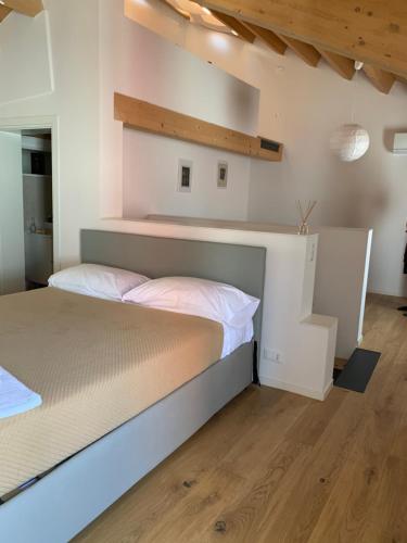 1 dormitorio con 1 cama grande y suelo de madera en Suite In Centro Storico, en Caorle