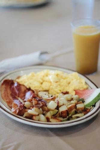 a plate of breakfast food with a glass of orange juice at Days Inn by Wyndham Show Low in Show Low