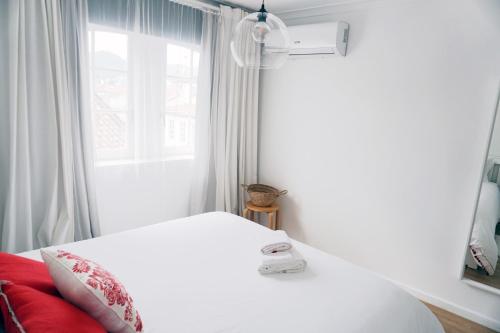 a bedroom with a white bed and a window at Casa da Laurindinha in Ponte de Lima