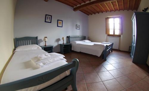 een slaapkamer met 2 bedden en een raam bij Agriturismo Il Palazzo in Pergine Valdarno