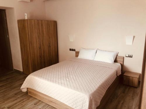 - une chambre avec un lit et une armoire en bois dans l'établissement Angela Apartments & Studio, à Fanárion