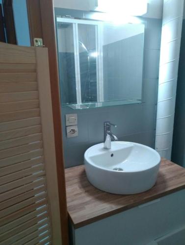 une salle de bain avec un lavabo blanc et un miroir dans l'établissement La Bergerie Crenantine, à Crenans
