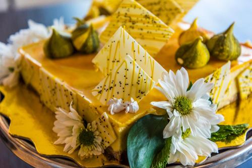 a yellow cake with white flowers on a plate at Holiday Inn Cúcuta by IHG in Cúcuta