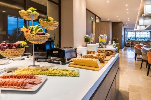 a breakfast buffet with bread and fruit on a counter at Holiday Inn Cúcuta by IHG in Cúcuta