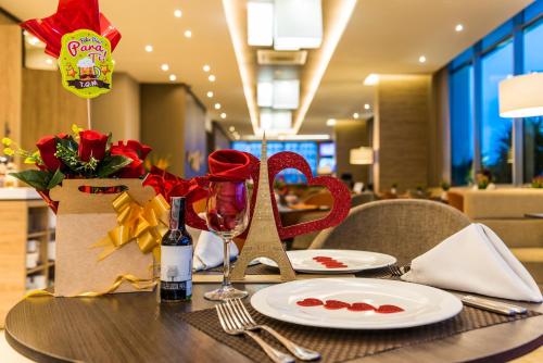 a table with a plate and wine glasses on it at Holiday Inn Cúcuta by IHG in Cúcuta