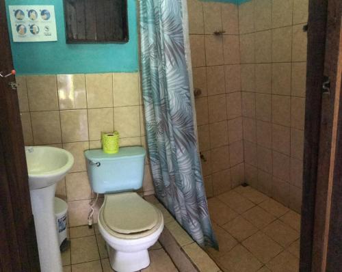 a bathroom with a toilet and a sink at All Rankins Eco-Lodge in Tortuguero