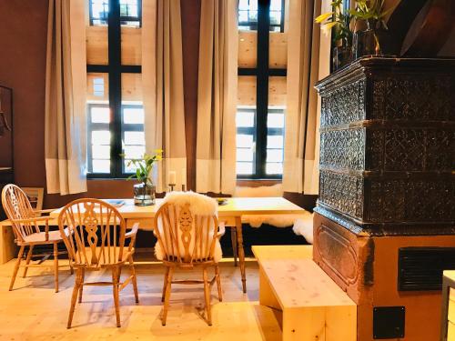 a dining room with a table and chairs and windows at ANNAS STUBE - Boutique Design Bauernhof in Waldkirch