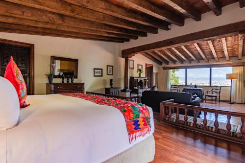 a bedroom with a bed and a living room at Villa Montaña Hotel & Spa in Morelia