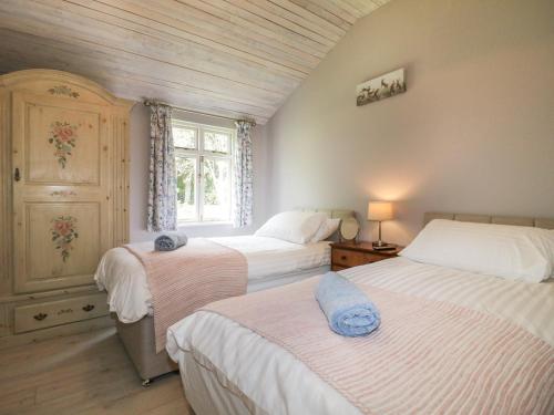 een slaapkamer met 2 bedden en een raam bij The Hen House in Rugeley