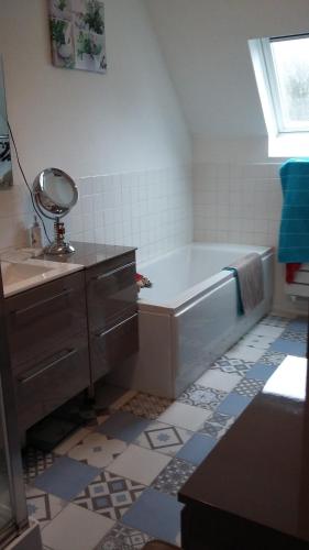 a bathroom with a tub and a sink with a mirror at pause à la campagne in Le Parcq