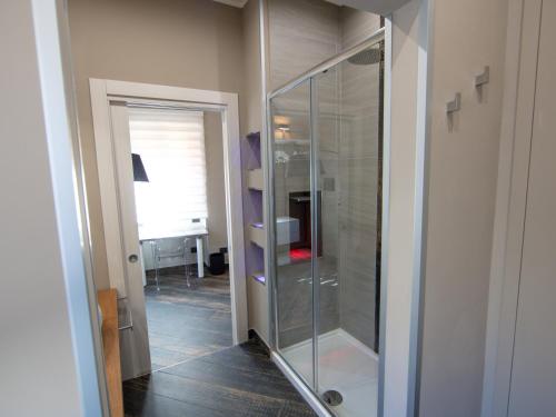 a glass shower in a room with a hallway at ALBAGIO' in Cittanova