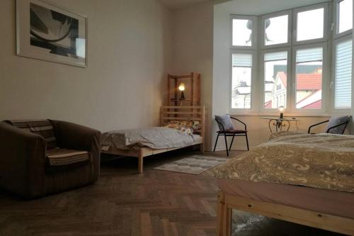 a bedroom with a bed and a chair and window at Apartament Barbara - przy rynku in Wadowice