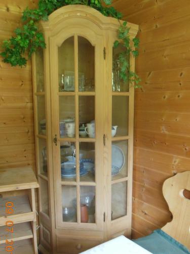 a wooden cabinet with dishes inside of it at Ferienwohnungen Josef & Karin Ketterl in Sachrang