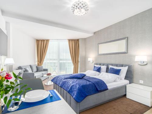 - une chambre avec un lit et un salon dans l'établissement Seaside Park Apartament Prywatny Kołobrzeg Lokservis - przy plaży, à Kołobrzeg