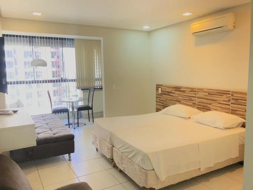 a bedroom with a bed and a table and a chair at ABC Apart Hotel in Brasilia