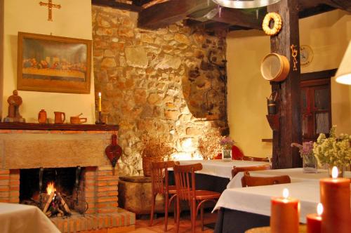 a dining room with a fireplace and tables and candles at La Casona de Tresgrandas in Tresgrandas