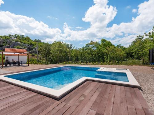 a swimming pool on a deck with a wooden deck at Bonaventura Countryside Villa near Split in Neorić
