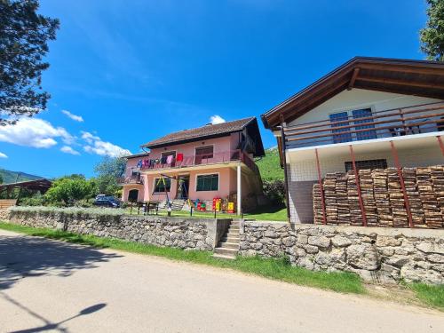 a house with a stone wall next to a road at Apartment Prole in Šipovo