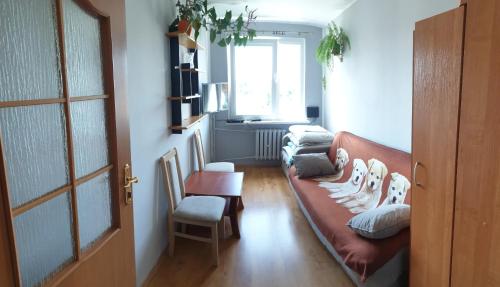 ein Wohnzimmer mit einem Sofa und einem Fenster in der Unterkunft Przytulne mieszkanie nad morzem in Ustronie Morskie