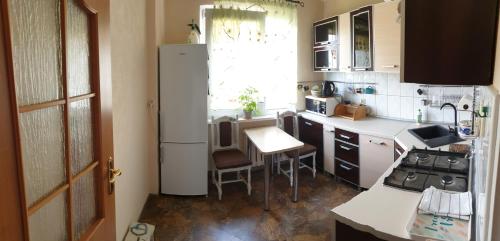 eine kleine Küche mit einem weißen Kühlschrank und einem Tisch in der Unterkunft Przytulne mieszkanie nad morzem in Ustronie Morskie