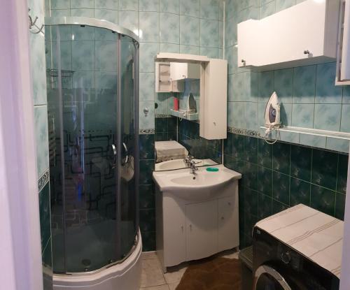 ein Bad mit einer Dusche und einem Waschbecken in der Unterkunft Przytulne mieszkanie nad morzem in Ustronie Morskie