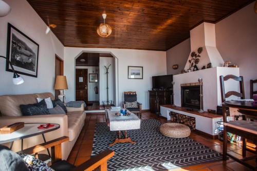 a living room with a couch and a fireplace at Apartamento Charmoso no Funchal, com grande Jardim e Vista Esplêndida in Funchal