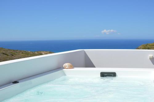 a bathtub in a boat with the ocean in the background at Milos Zen Suites in Adamantas