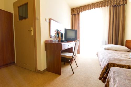 a hotel room with a desk with a computer on it at Apartamenty Renesans in Krynica Zdrój