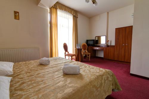 a hotel room with a bed with two towels on it at Apartamenty Renesans in Krynica Zdrój