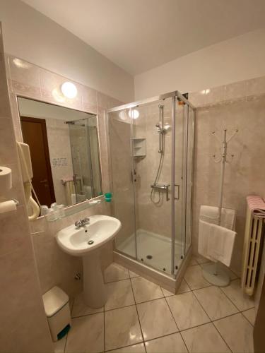 a bathroom with a glass shower and a sink at Hotel Fiorentino in Stresa