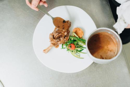 un plato blanco con comida y una taza de café en Hôtel Montmirail en Gigondas