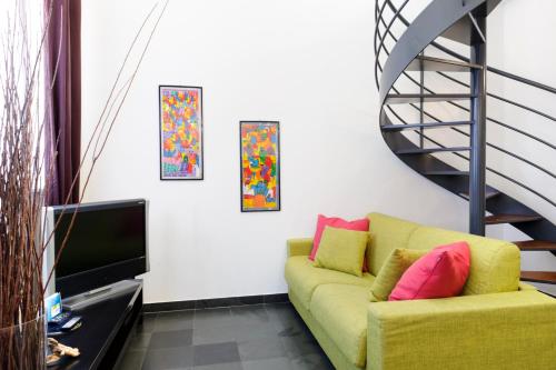 sala de estar con sofá amarillo y escalera en Isola Apartments, en Milán