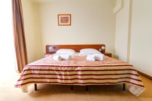 a bedroom with a bed with two towels on it at Apartamenty Renesans in Krynica Zdrój